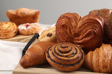 Different tasty freshly baked pastries on table, closeup