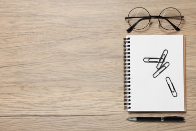 Different stationery and glasses on wooden desk, flat lay with space for text. Home office