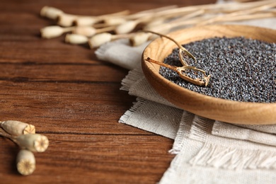 Plate with poppy seeds on wooden table