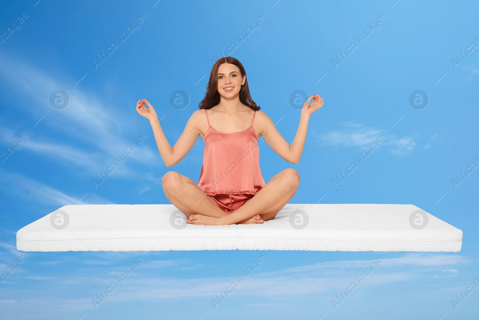 Image of Healthy sleep. Young woman on comfortable mattress in blue sky