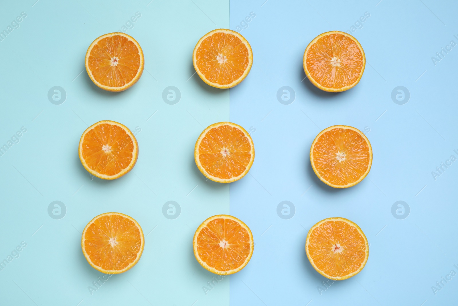 Photo of Cut oranges on color background, flat lay