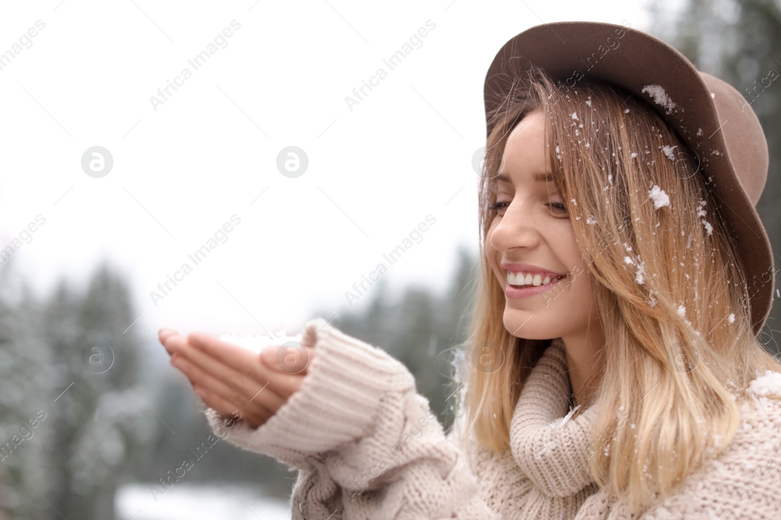 Photo of Young woman playing with snow outdoors. Winter vacation