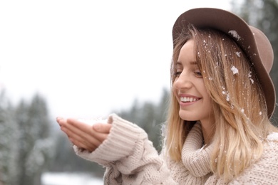 Photo of Young woman playing with snow outdoors. Winter vacation