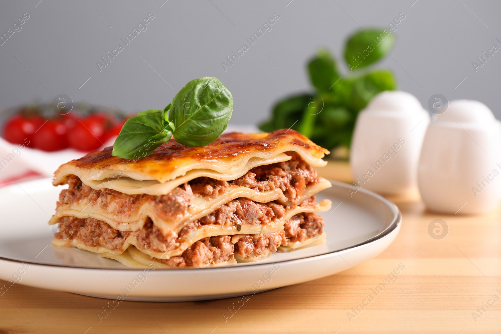 Photo of Delicious cooked lasagna served on wooden table