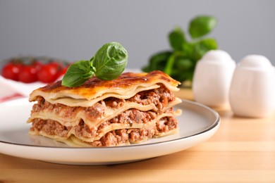 Photo of Delicious cooked lasagna served on wooden table