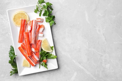 Delicious crab sticks served on light grey marble table, flat lay. Space for text