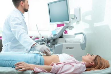 Photo of Doctor conducting ultrasound examination of internal organs in clinic. Space for text