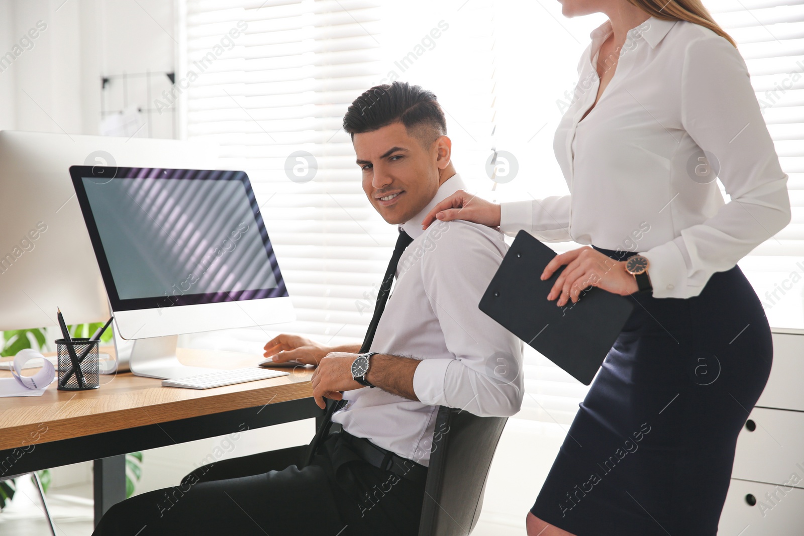 Photo of Young woman flirting with her colleague during work in office