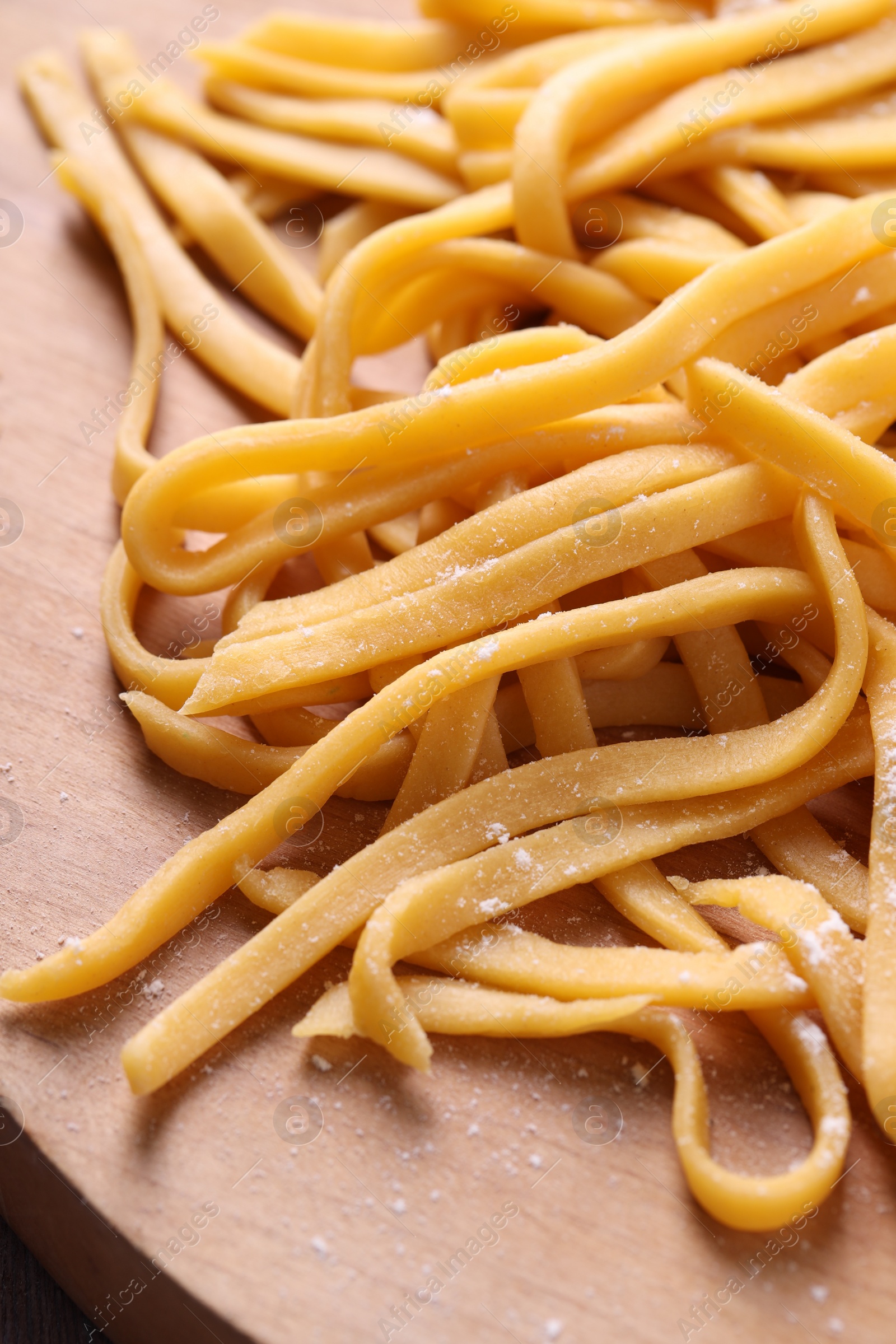 Photo of Raw homemade pasta on wooden table, closeup