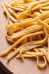 Photo of Raw homemade pasta on wooden table, closeup