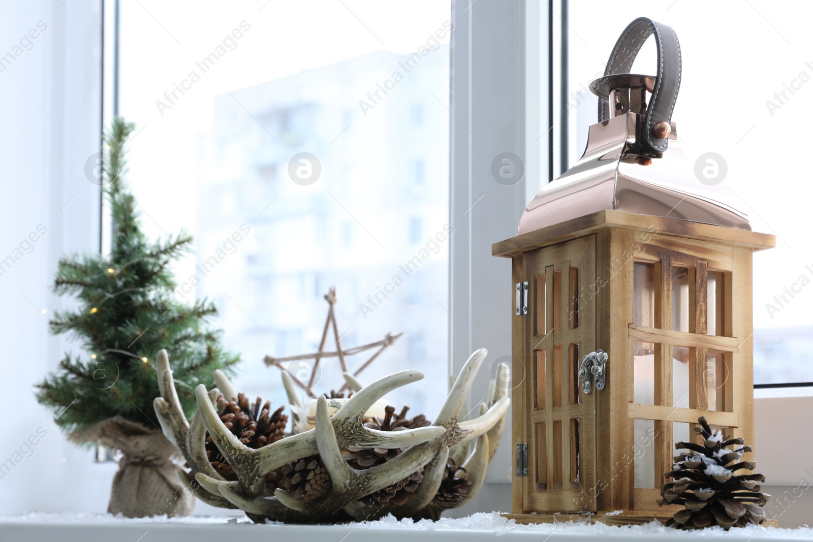 Photo of Beautiful Christmas lantern and other decorations on window sill