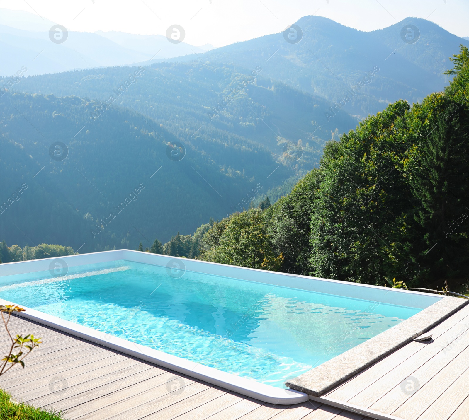 Image of Outdoor swimming pool at luxury resort and beautiful view of mountains on sunny day