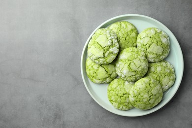 Photo of Plate with tasty matcha cookies on grey table, top view. Space for text