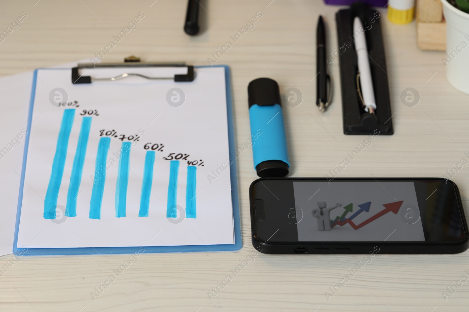 Photo of Business process planning and optimization. Workplace with graph, smartphone and different stationery on wooden table