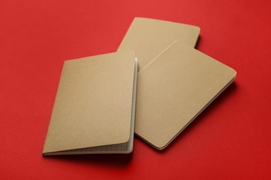 Photo of New stylish kraft planners on red background