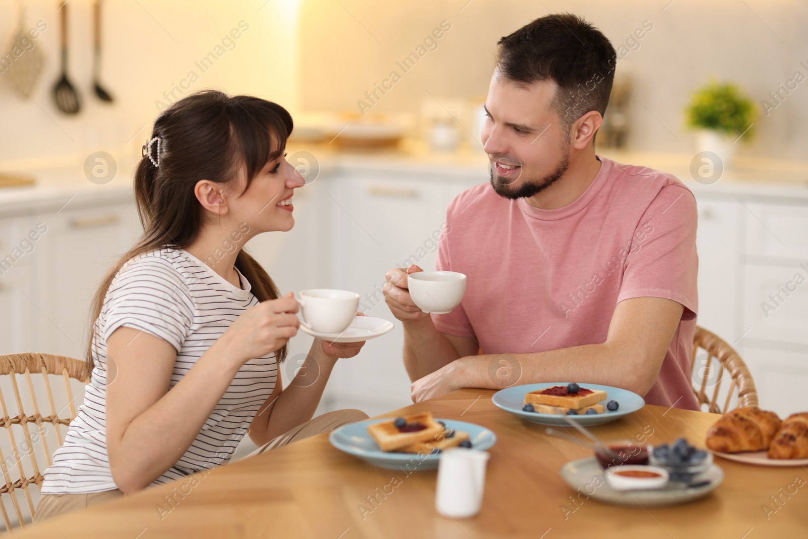 Photo of Happy couple having tasty breakfast at home