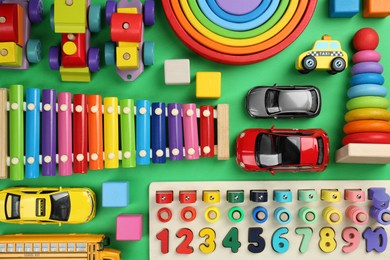 Different children's toys on green background, flat lay