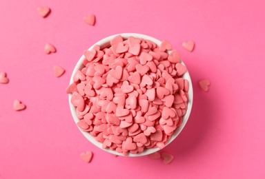Photo of Heart shaped sprinkles on pink background, flat lay