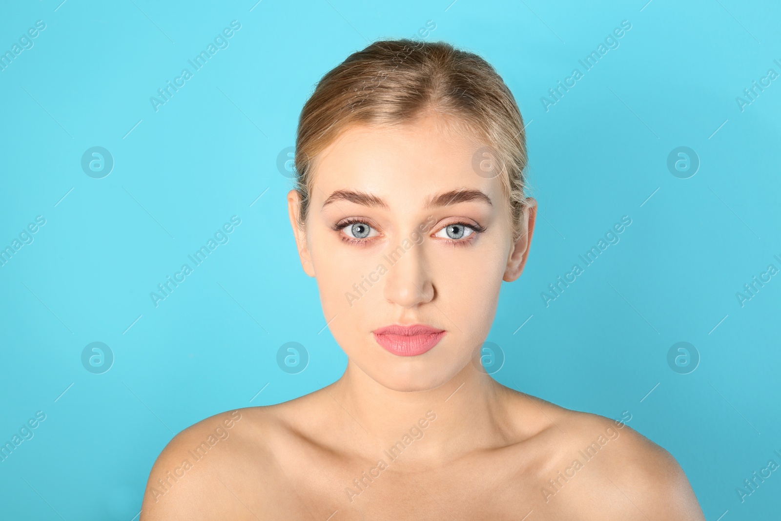 Photo of Portrait of young woman with beautiful natural eyelashes on color background