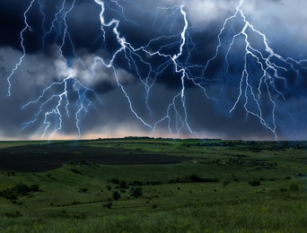 Image of Dark cloudy sky with lightnings. Picturesque thunderstorm over field