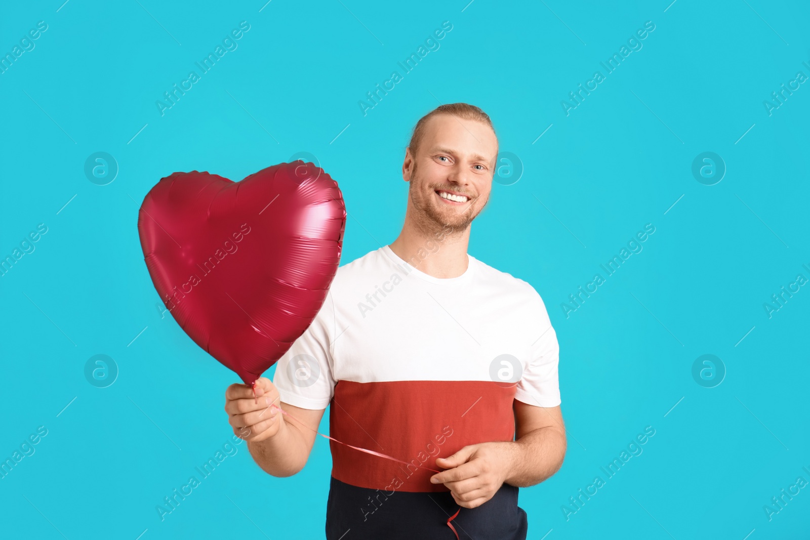 Photo of Portrait of man with heart shaped balloon on color background