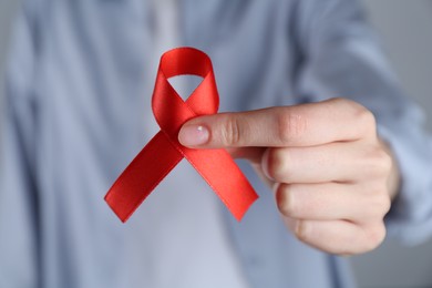 Photo of Woman with red awareness ribbon, closeup view