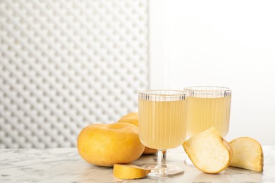 Photo of Glasses of freshly made turnip juice on white marble table, space for text