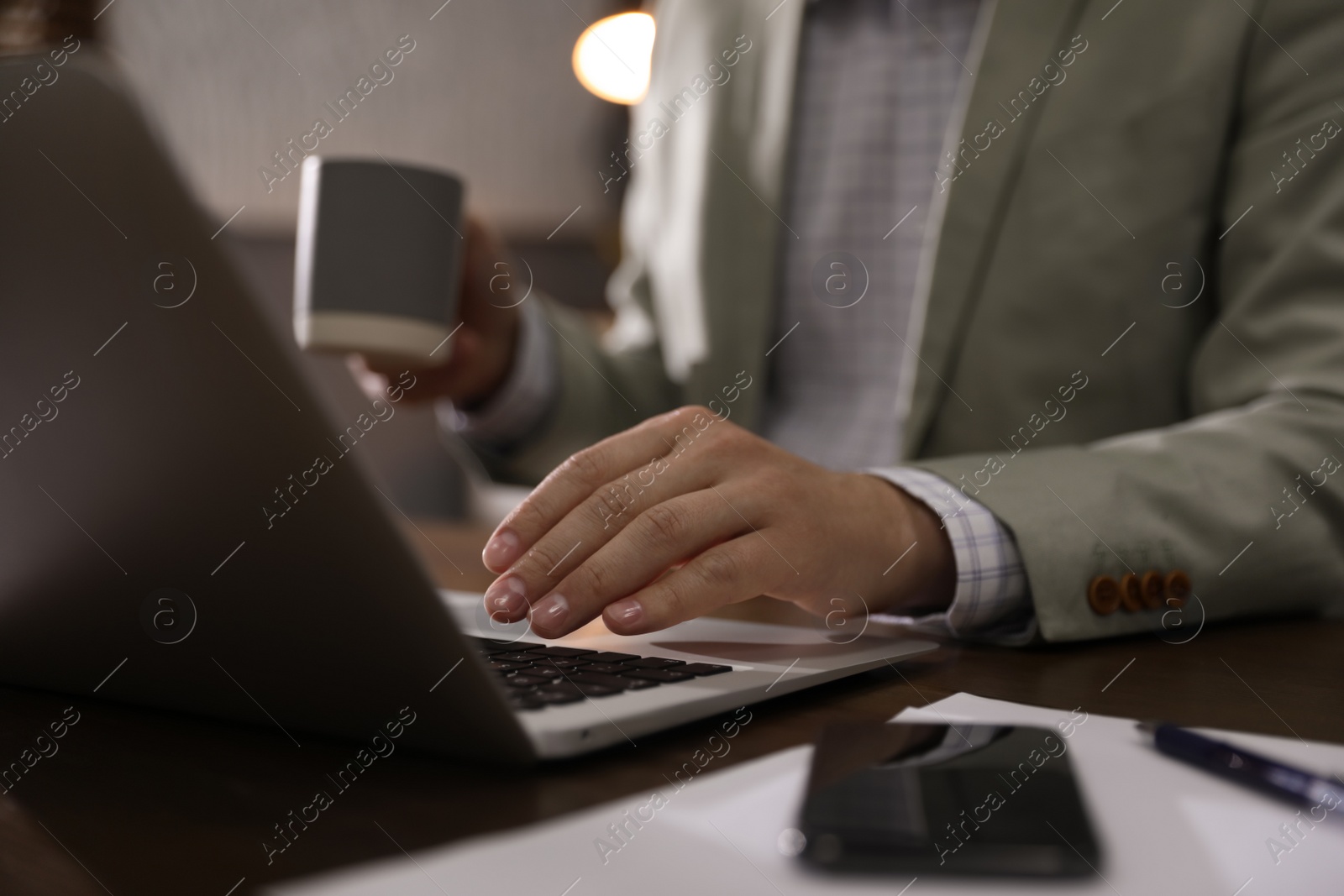 Photo of Man working with laptop in office, closeup of hand