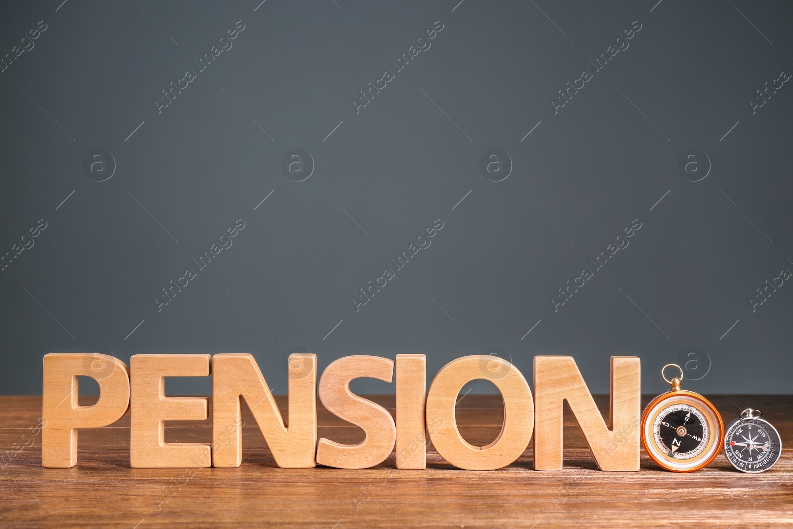 Photo of Word "PENSION" made of letters and compasses on wooden table