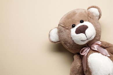 Photo of Cute teddy bear on beige background, top view. Space for text
