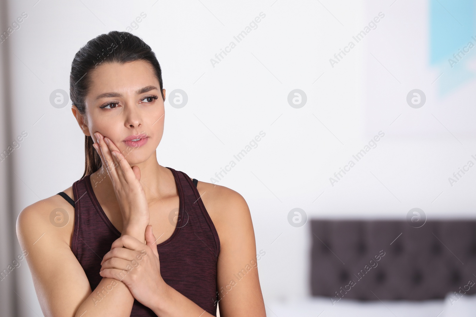 Photo of Young woman with sensitive teeth indoors. Space for text