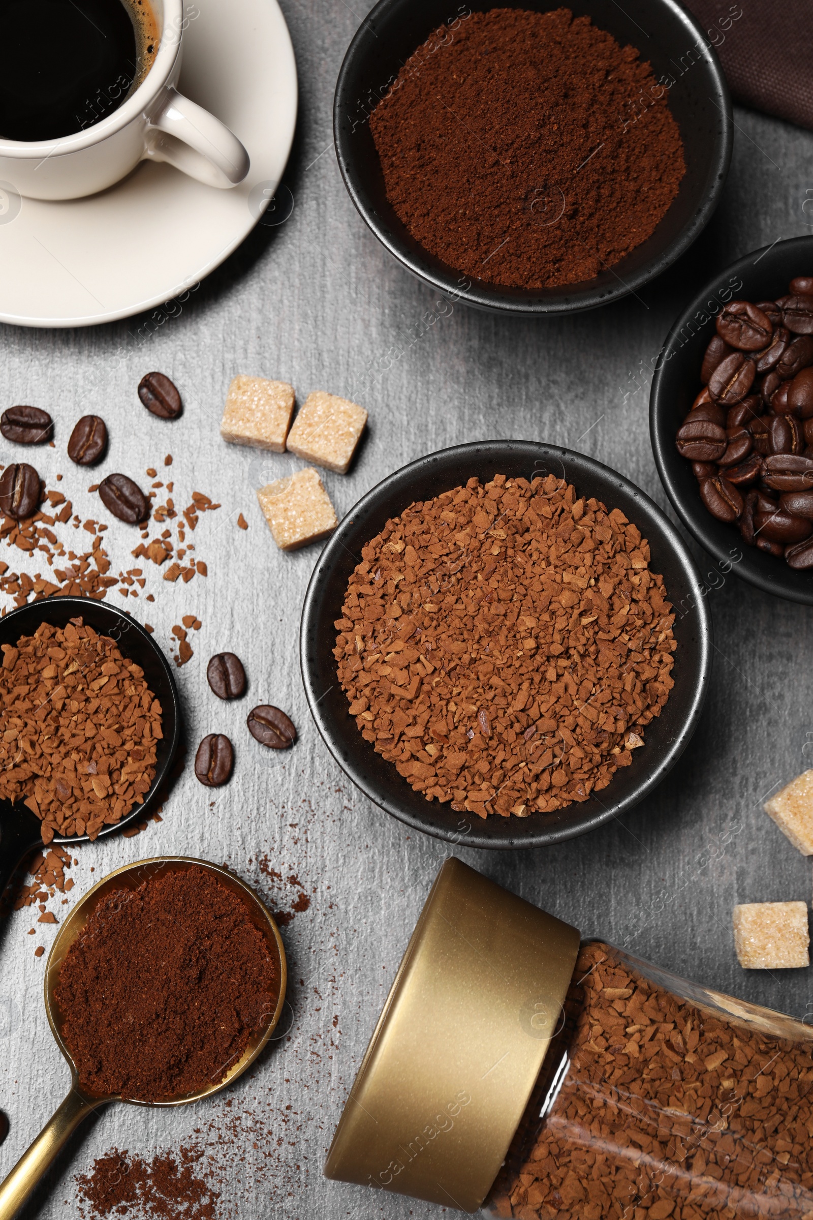 Photo of Flat lay composition with beans, instant and ground coffee on grey table