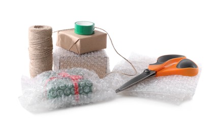 Cardboard boxes, bubble wrap, scissors and adhesive tape on white background