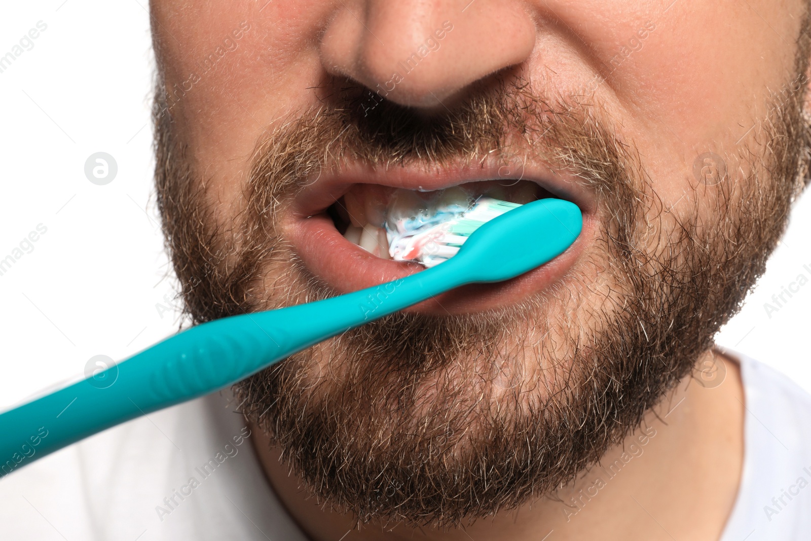 Photo of Man brushing teeth with paste on white background, closeup. Dental care