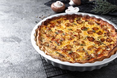 Photo of Delicious pie with mushrooms and cheese on grey table