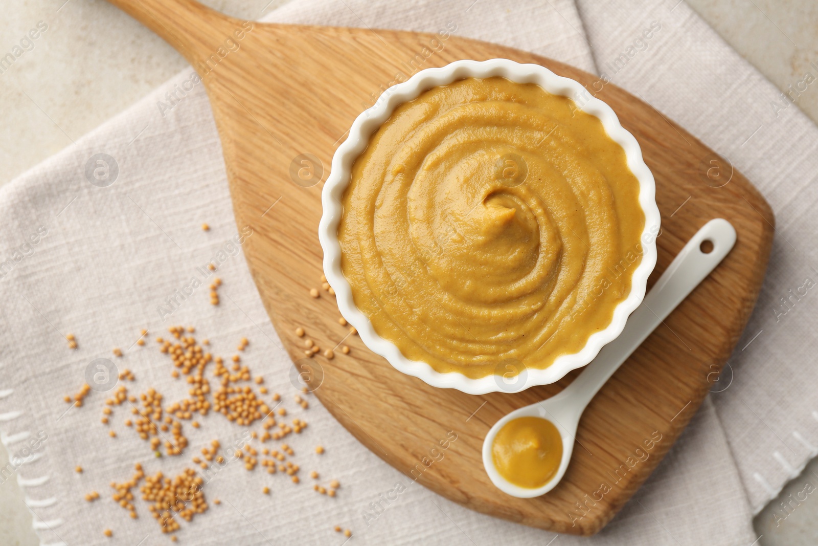 Photo of Tasty mustard sauce and dry seeds on light table, flat lay