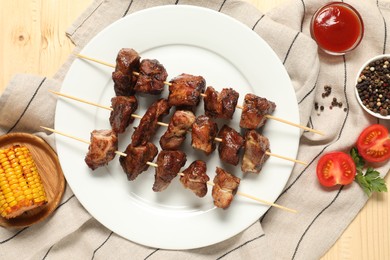 Photo of Delicious shish kebabs served on wooden table, flat lay