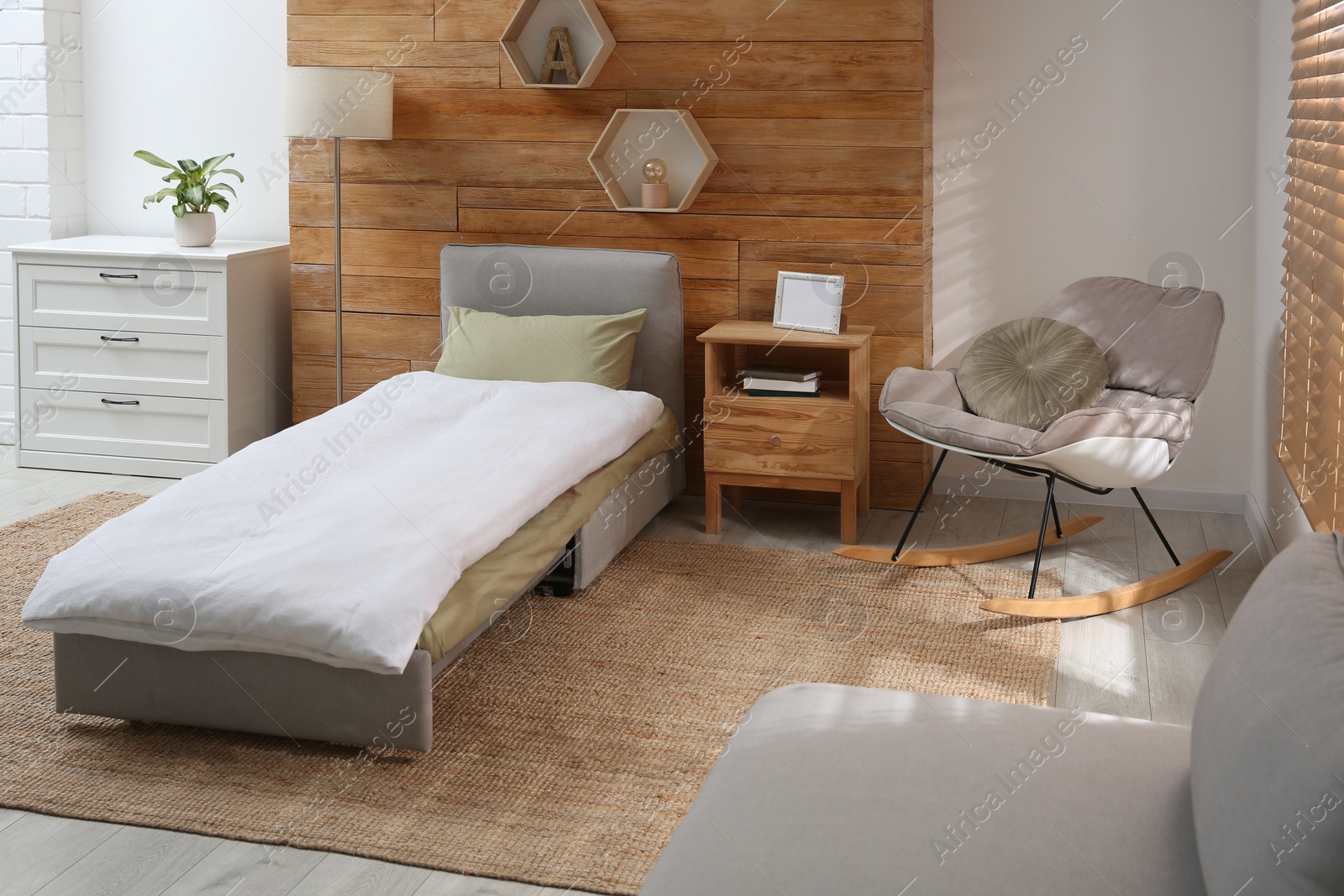 Photo of Room interior with sleeper sofa near wooden wall. Additional place for guest