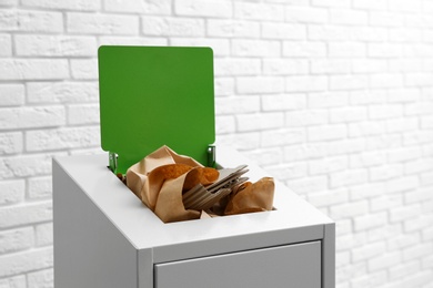 Photo of Trash bin with paper and cardboard near brick wall, space for text. Recycling concept