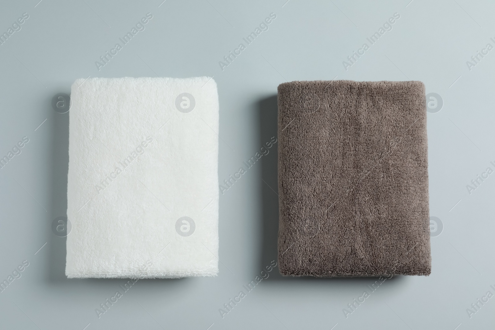 Photo of Soft folded towels on light background, top view