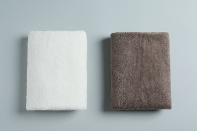 Photo of Soft folded towels on light background, top view