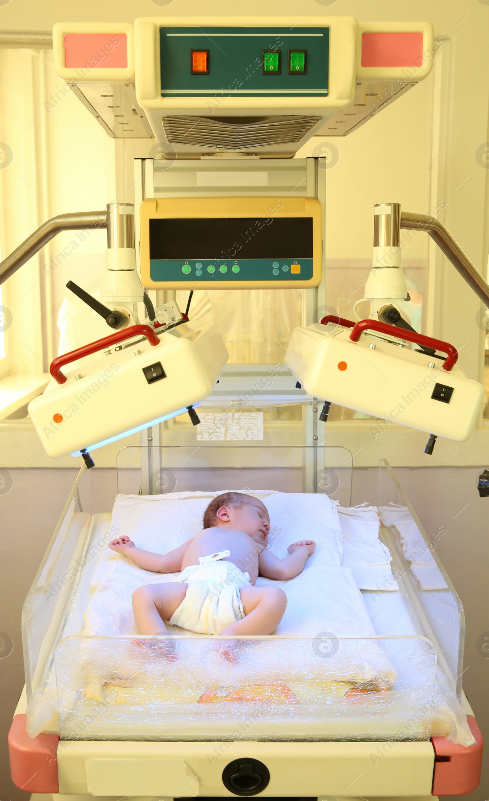 Photo of Newborn child under ultraviolet lamps in hospital