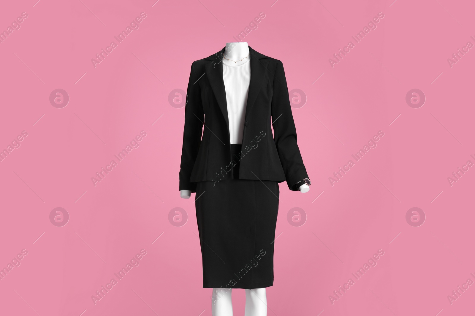 Photo of Female mannequin with accessories dressed in black classic suit and white t-shirt on pink background