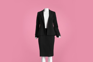 Photo of Female mannequin with accessories dressed in black classic suit and white t-shirt on pink background