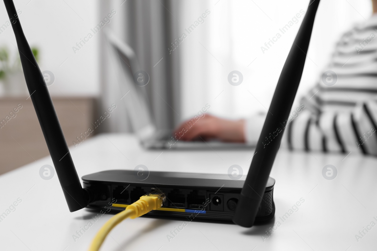 Photo of Woman working in office, focus on connected with cable router. Wireless internet communication