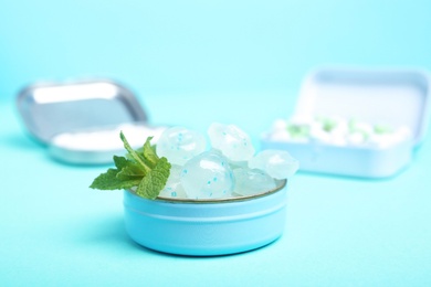 Photo of Open box with tasty mint candies and leaves on color background