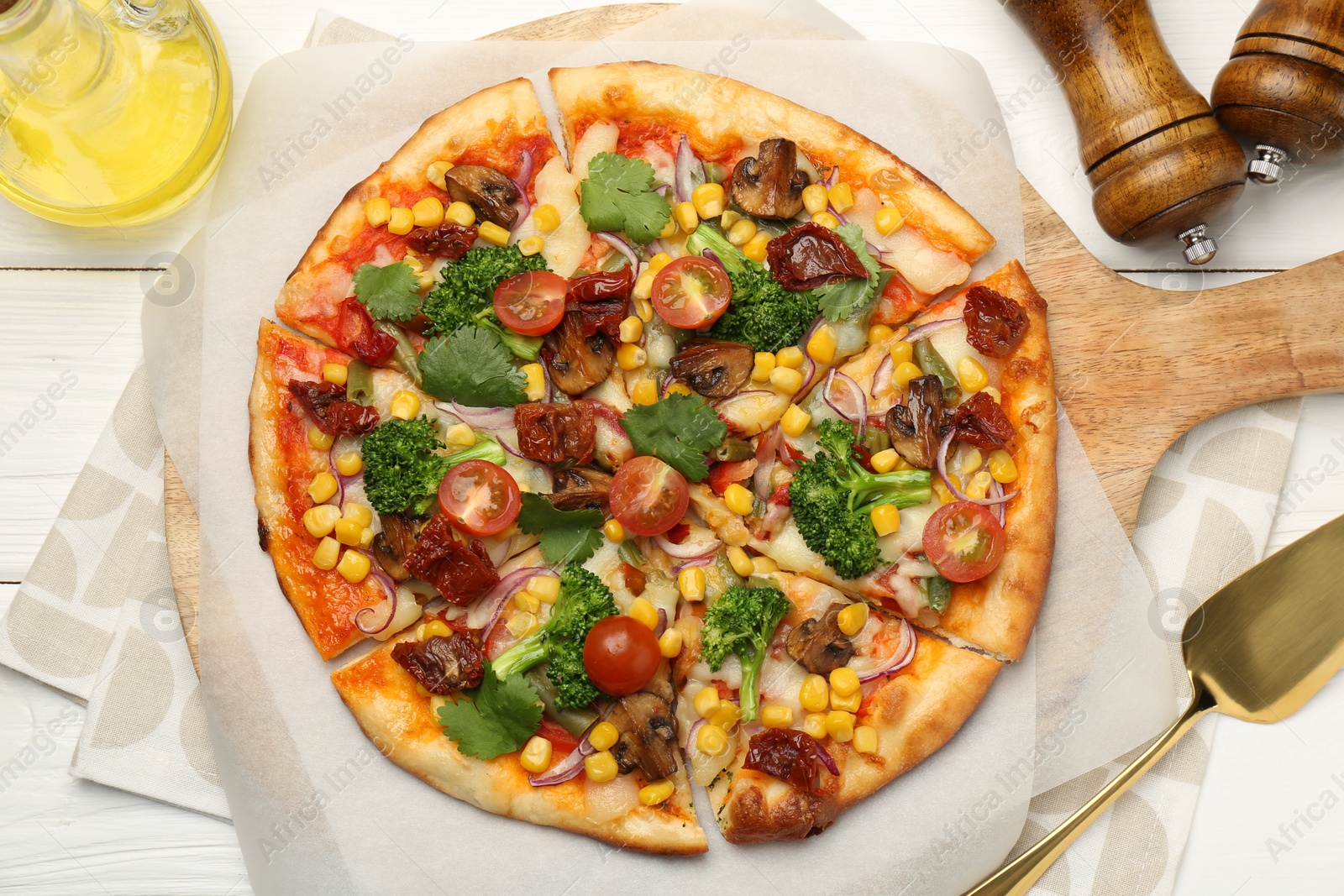 Photo of Delicious vegetarian pizza and server on white wooden table, top view