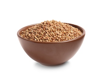 Bowl with uncooked buckwheat on white background