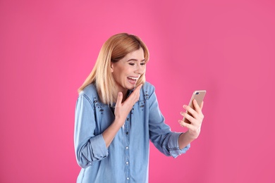 Photo of Woman using mobile phone for video chat on color background