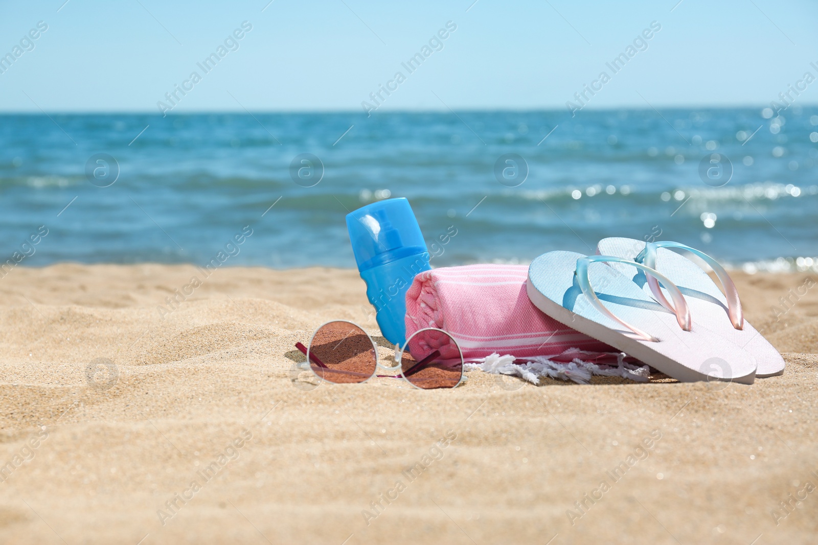 Photo of Set of different beach objects on sand near sea. Space for text